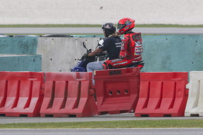 Marc Marquez riding back to the paddock on a scooter after crashing, 2025 MotoGP Sepang Test. Credit: Gold and Goose.