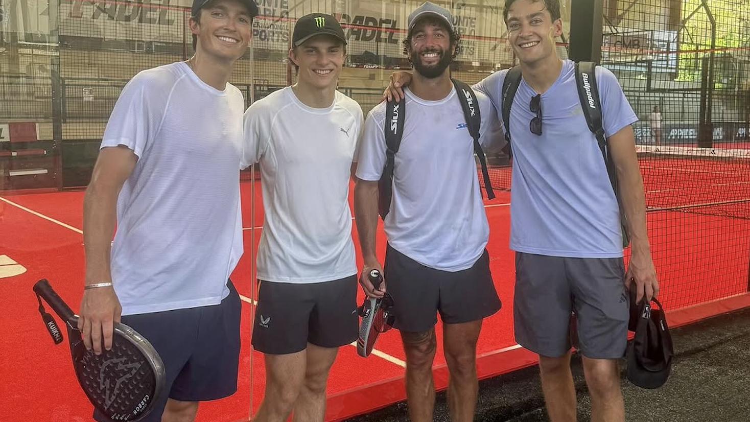 Daniel Ricciardo stands in between Oscar Piastri and George Russell