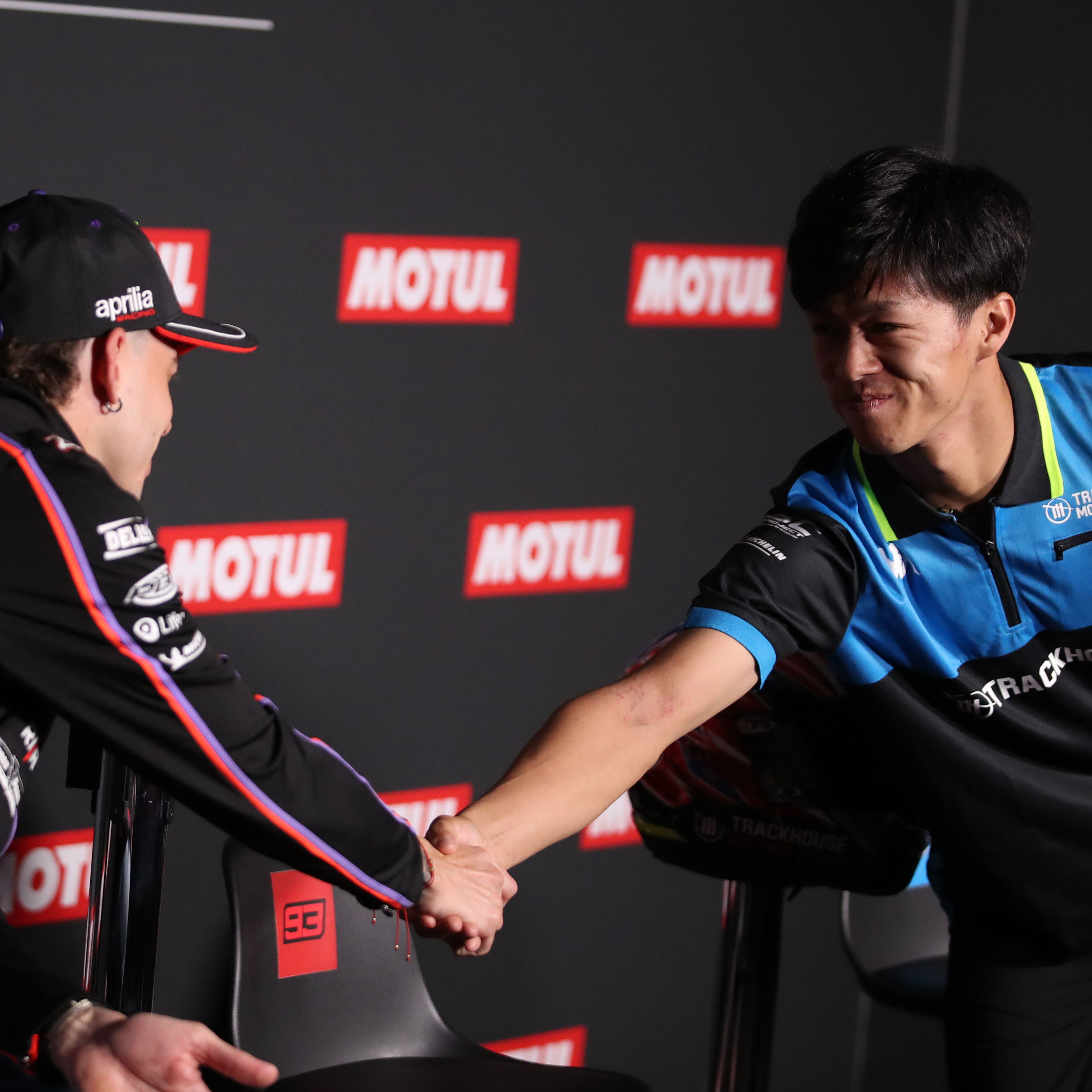 Ai Ogura and Marco Bezzecchi shake hands during the 2025 MotoGP Japanese Grand Prix pre-event press conference. Credit: Gold and Goose.
