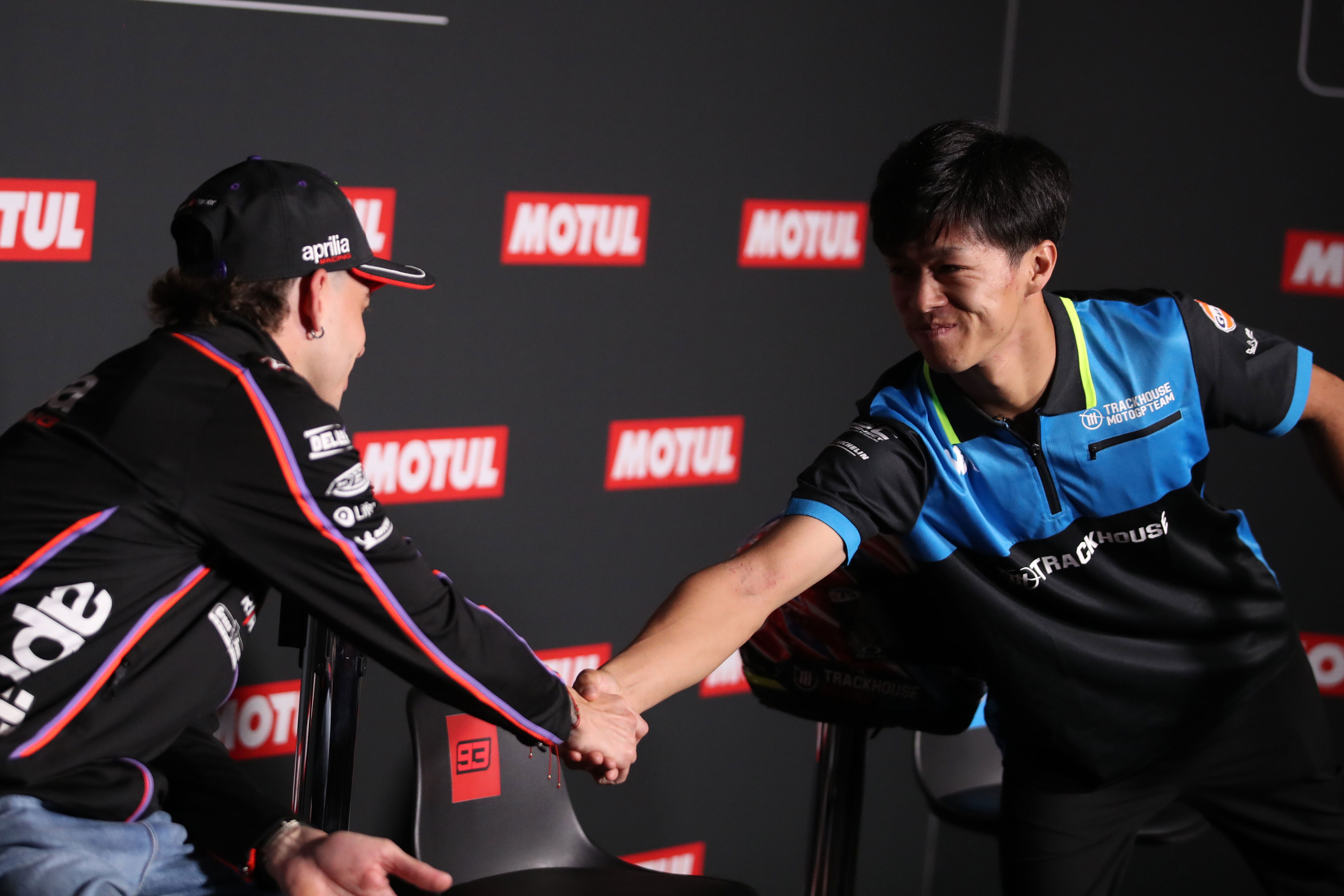 Ai Ogura and Marco Bezzecchi shake hands during the 2025 MotoGP Japanese Grand Prix pre-event press conference. Credit: Gold and Goose.