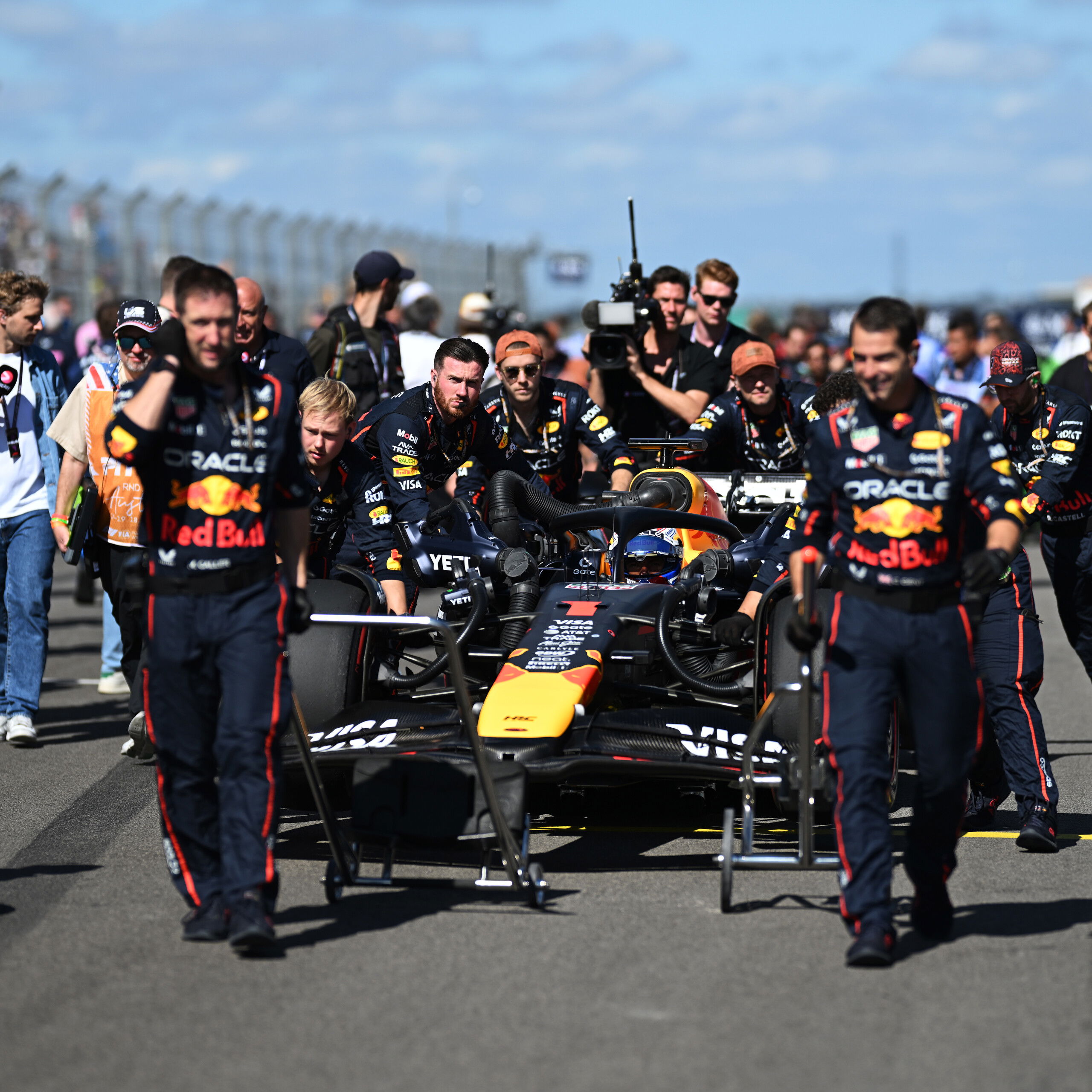 Red Bull crew wheel Max Verstappen onto the grid