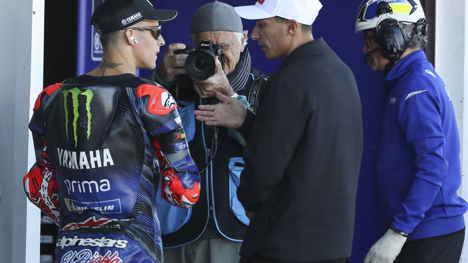 Fabio Quartararo speaks with Toprak Razgatlioglu, 2025 MotoGP Valencia Grand Prix, pit lane. Credit: Gold and Goose.