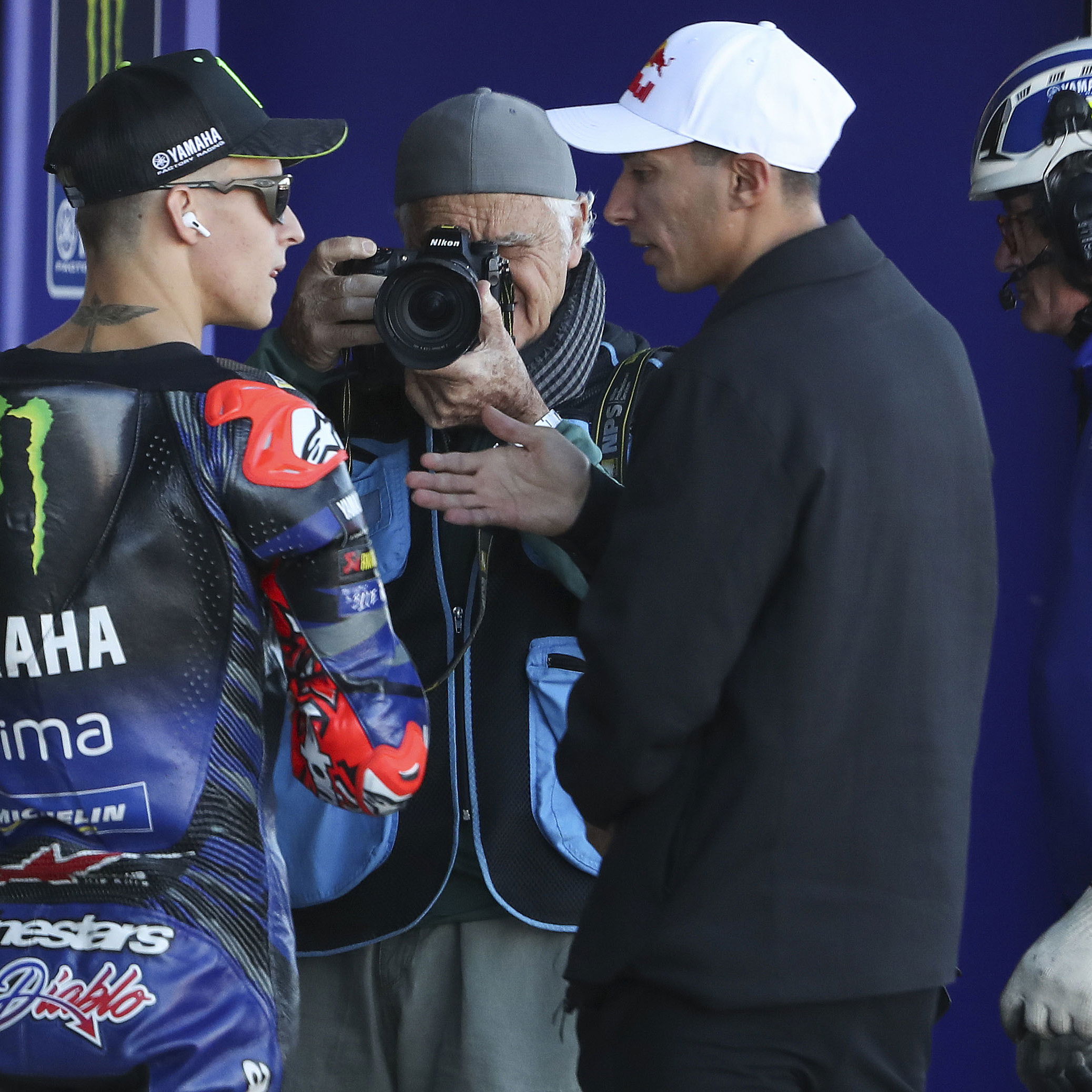 Fabio Quartararo speaks with Toprak Razgatlioglu, 2025 MotoGP Valencia Grand Prix, pit lane. Credit: Gold and Goose.