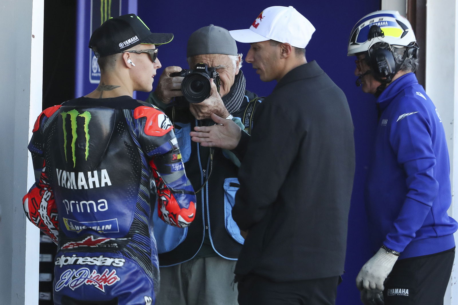 Fabio Quartararo speaks with Toprak Razgatlioglu, 2025 MotoGP Valencia Grand Prix, pit lane. Credit: Gold and Goose.