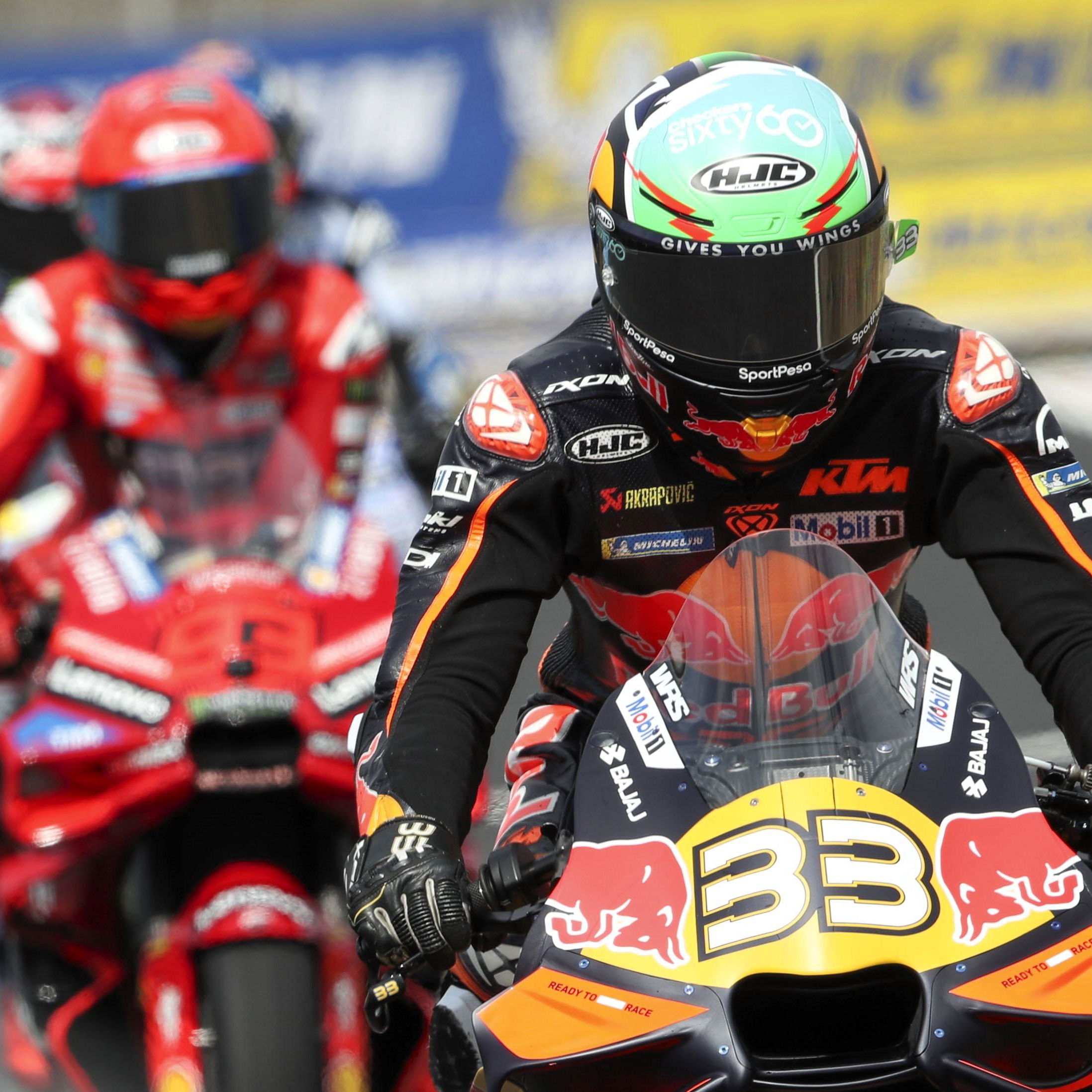 Brad Binder leads Marc Marquez out of the pits during MotoGP 2025.