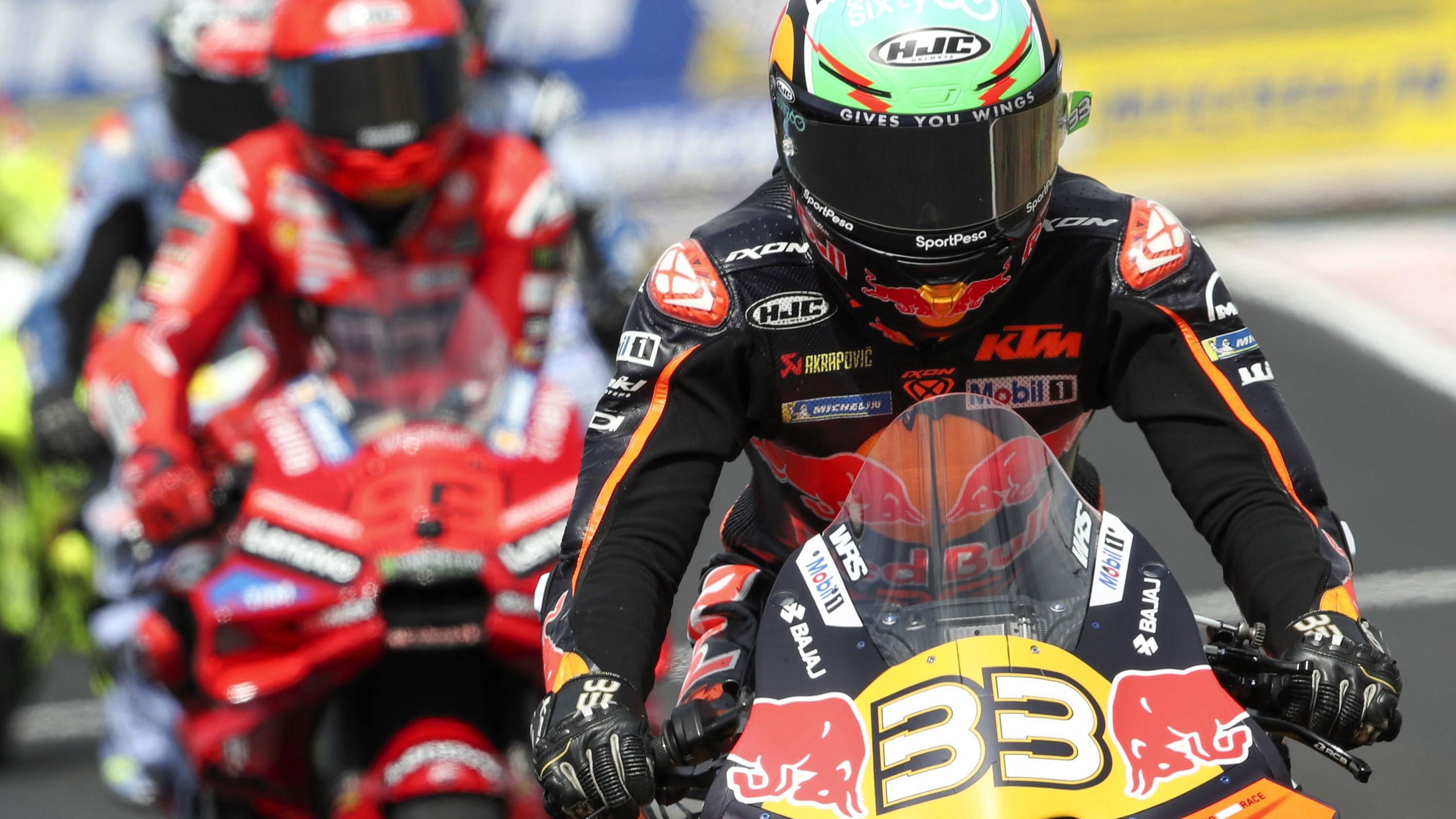 Brad Binder leads Marc Marquez out of the pits during MotoGP 2025.