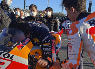 Marc Marquez teaches Sergio Perez the RC213V's controls (Pic: Repsol Honda)