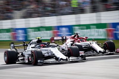 Pierre Gasly (FRA) AlphaTauri AT01 and Kimi Raikkonen (FIN) Alfa Romeo Racing C39.