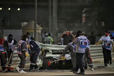 Marshals work on the circuit after Romain Grosjean (FRA) Haas F1 Team VF-20 crashed at the start of the race and exploded into flames.