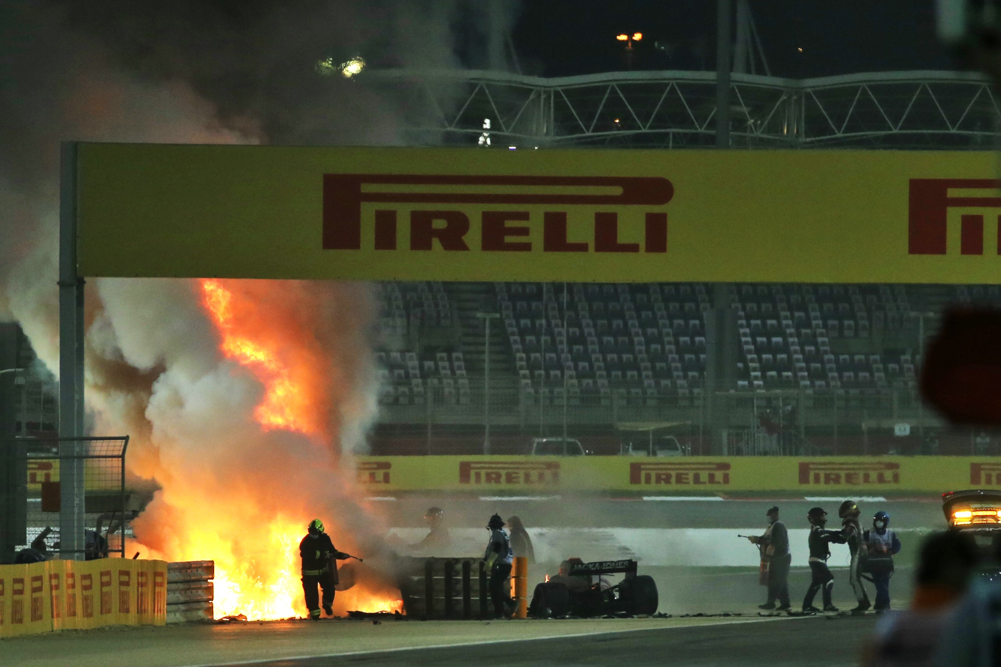 Romain Grosjean (FRA) is pulled clear of his burning Haas VF-20 by Dr Ian Roberts (GBR) FIA Doctor at the start of the race.