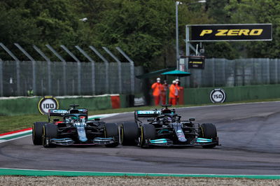 (L to R): Lance Stroll (CDN) Aston Martin F1 Team AMR21 dan Lewis Hamilton (GBR) Mercedes AMG F1 W12 memperebutkan posisi.