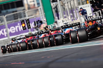 Fernando Alonso (ESP) Alpine F1 Team A521 and Max Verstappen (NLD) Red Bull Racing RB16B at the end of a queue of cars leaving the pits.