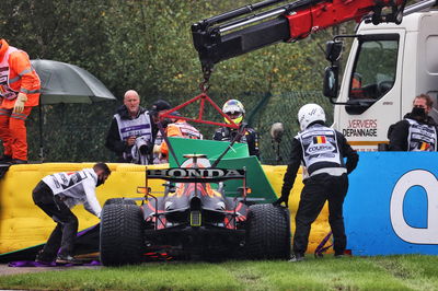 The Red Bull Racing RB16B of Sergio Perez (MEX) is craned away from the circuit after he crashed heading to the grid.