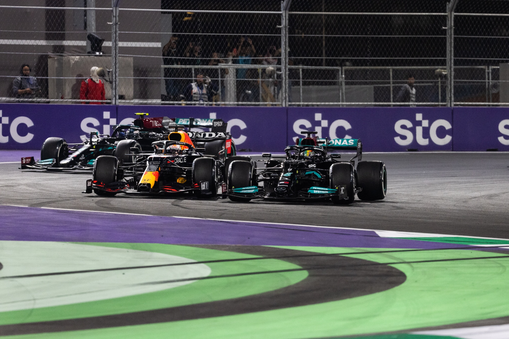 Lewis Hamilton (GBR) Mercedes AMG F1 W12 dan Max Verstappen (NLD) Red Bull Racing RB16B bertarung untuk memimpin pada balapan pertama dimulai ulang.