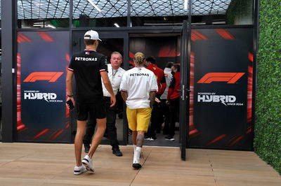 George Russell (GBR) Mercedes AMG F1 and Lewis Hamilton (GBR) Mercedes AMG F1 at a meeting following a missile strike on an Aramco oil facility near to the circuit.