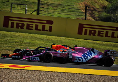 Alexander Albon (THA) Red Bull Racing RB16 and Sergio Perez (MEX) Racing Point F1 Team RP19 battle for position.