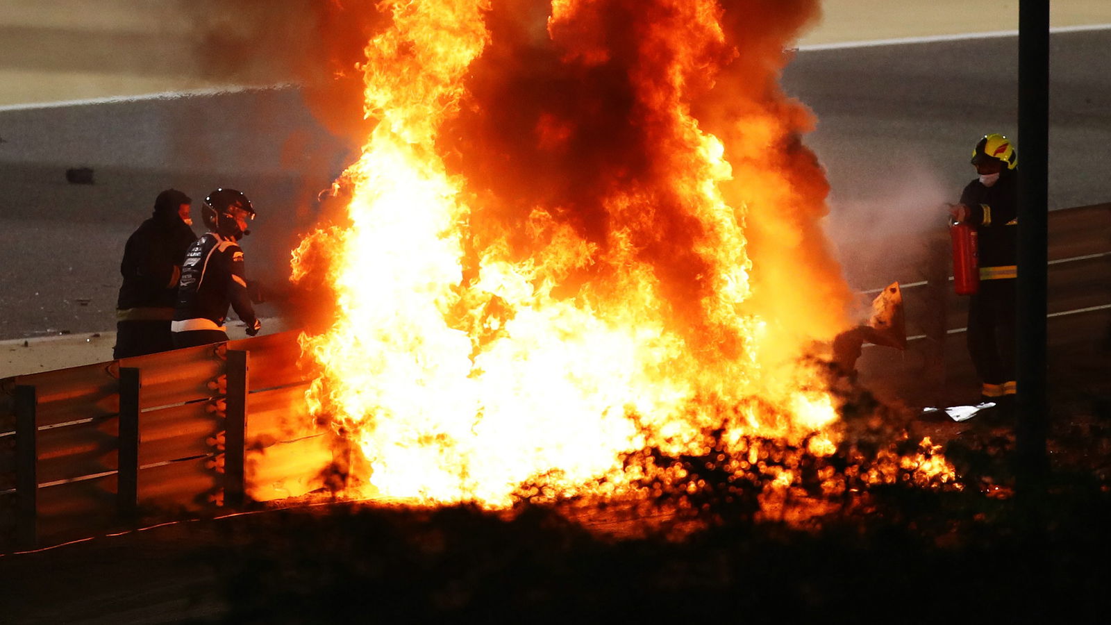 Marshals put out the fire of Romain Grosjean (FRA) Haas F1 Team at the start of the race, with Dr Ian Roberts (GBR) FIA