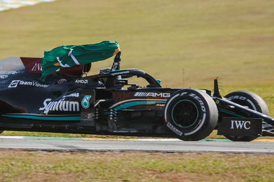 Pemenang balapan Lewis Hamilton (GBR) Mercedes AMG F1 W12 merayakan membawa bendera Brasil di akhir