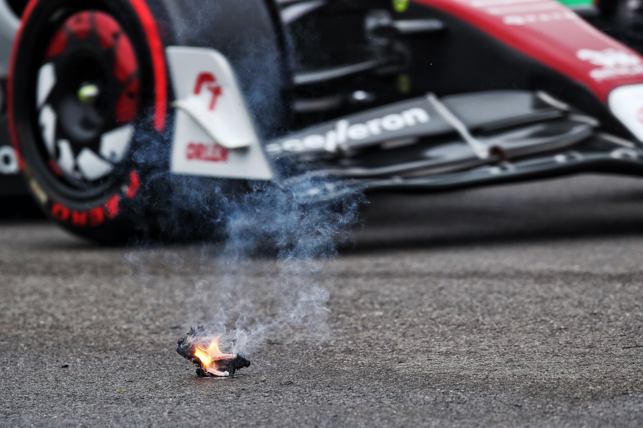 An Alfa Romeo F1 Team C42 passes some smoking debris from the Williams Racing FW44 of Alexander Albon (THA). Formula 1
