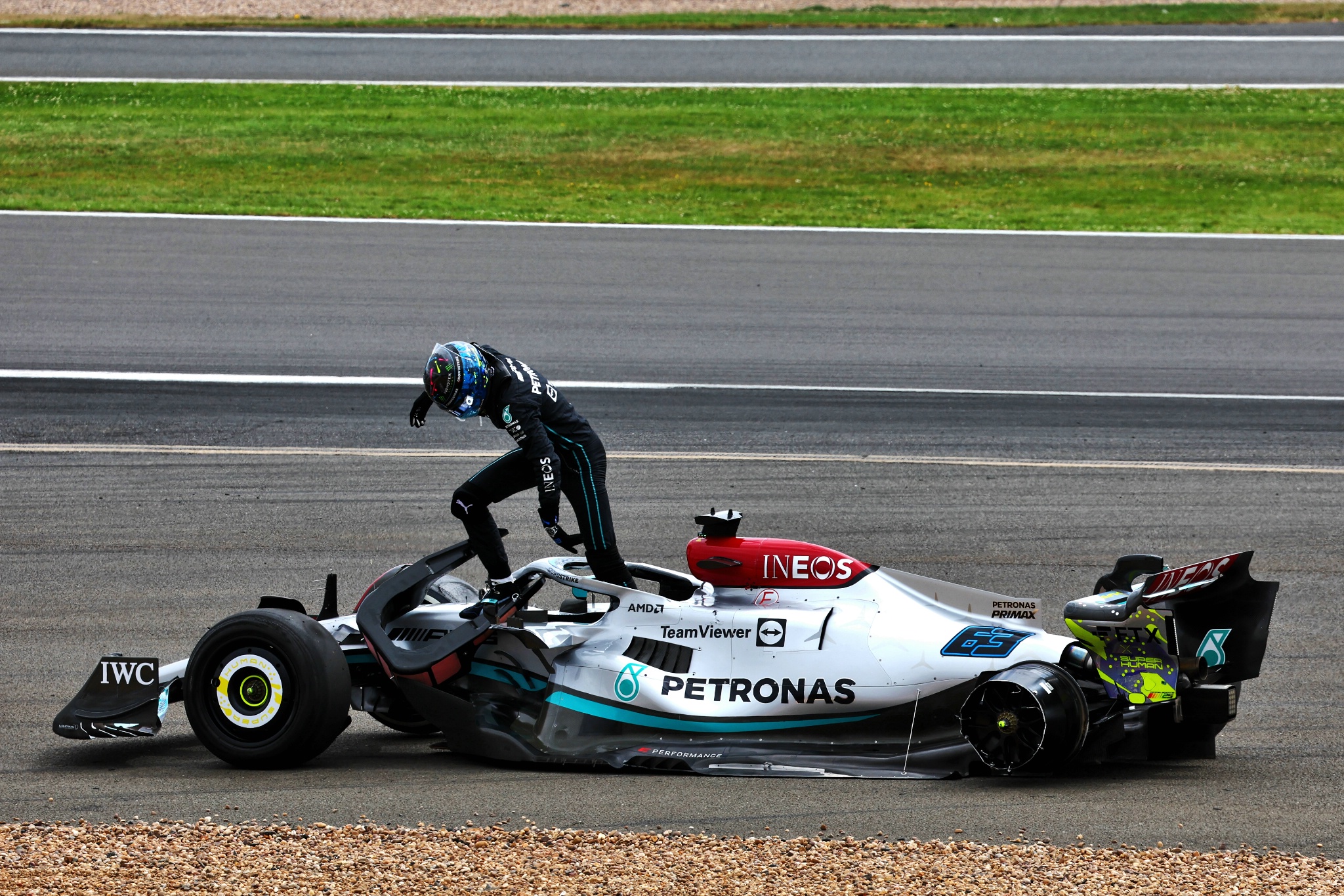 George Russell (GBR) Mercedes AMG F1 W13 crashed at the start of the race, rushes to check the condition of Guanyu Zhou