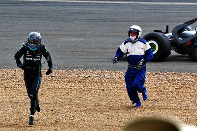 George Russell (GBR) Mercedes AMG F1 W13 crashed at the start of the race, rushes to check the condition of Guanyu Zhou