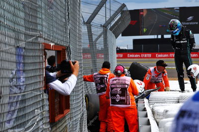 George Russell (GBR) Mercedes AMG F1 checks the condition of Guanyu Zhou (CHN) Alfa Romeo F1 Team C42 after they crashed out