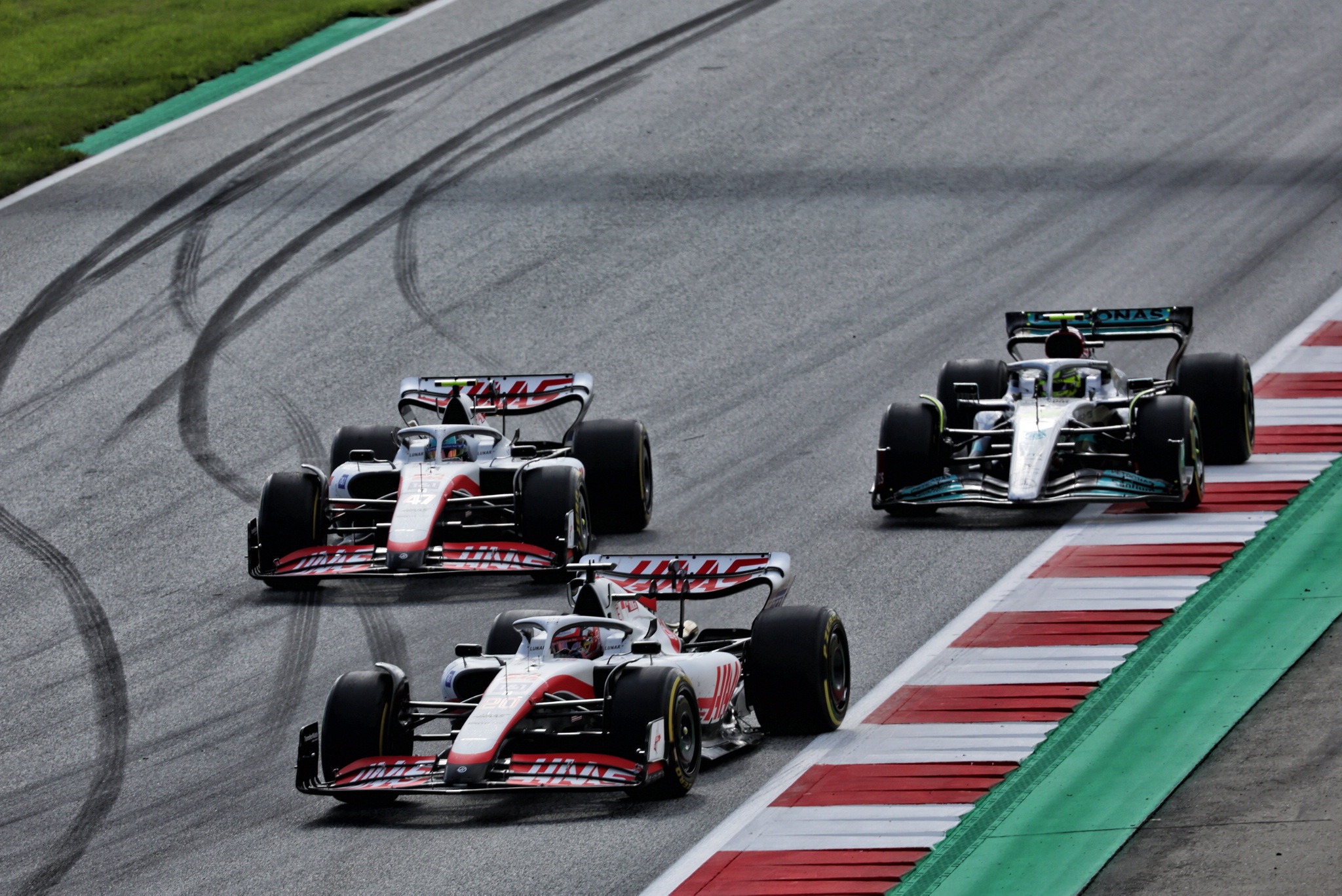(L to R): Kevin Magnussen (DEN) Haas VF-22 leads Mick Schumacher (GER) Haas VF-22 and Lewis Hamilton (GBR) Mercedes AMG F1