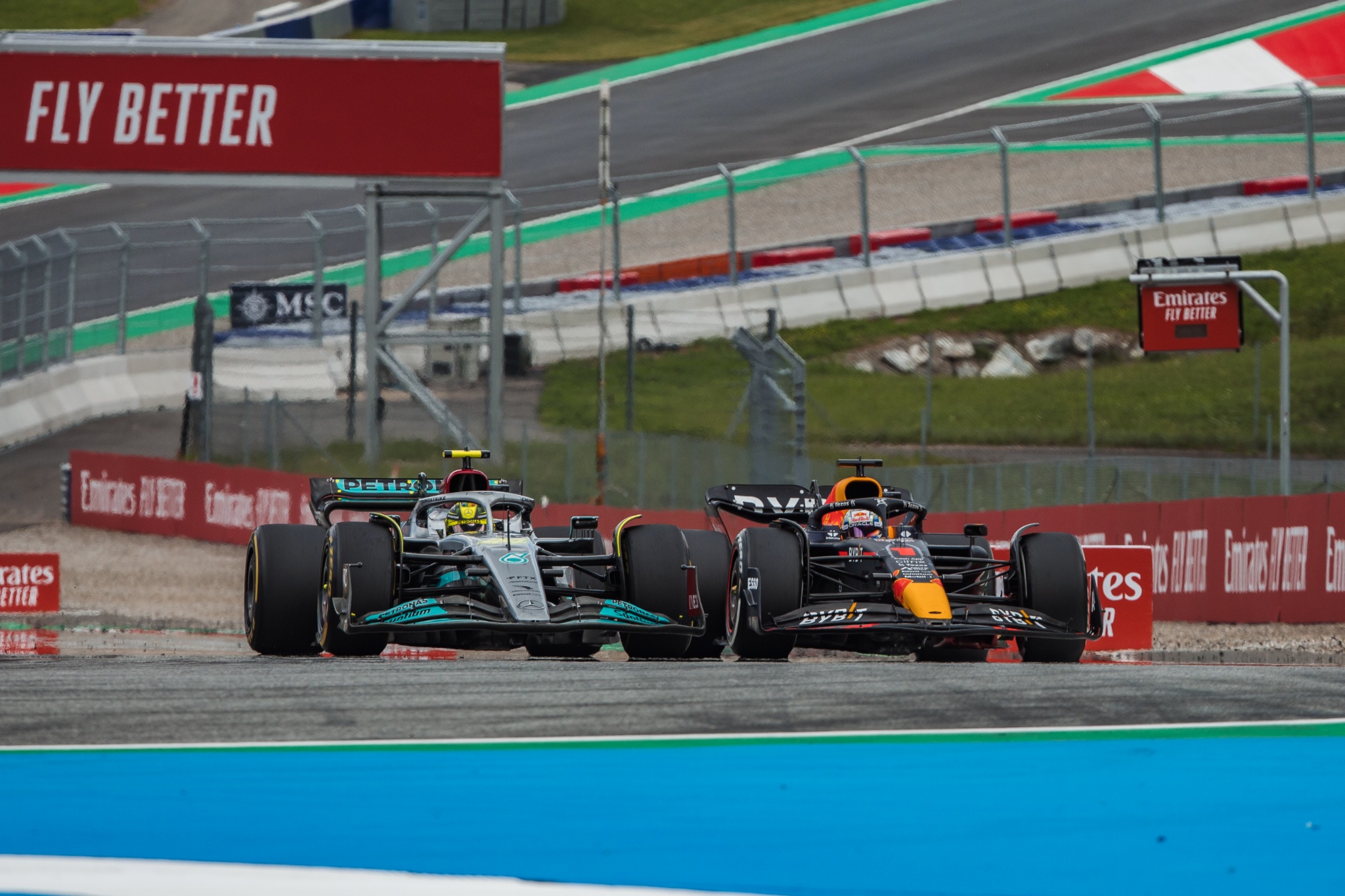 Lewis Hamilton (GBR) ) Mercedes AMG F1 W13 dan Max Verstappen (NLD) Red Bull Racing RB18 memperebutkan posisi. Formula 1