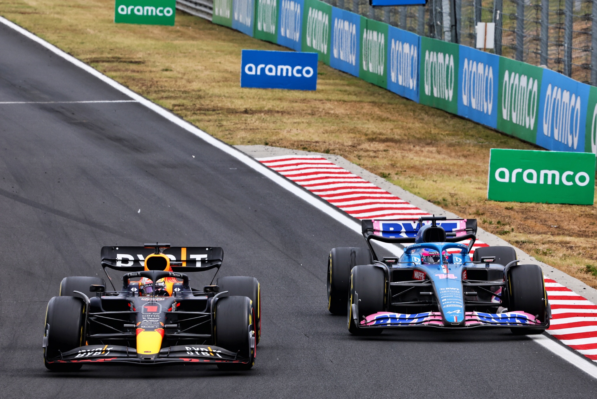(L ke R ): Max Verstappen (NLD) Red Bull Racing RB18 dan Fernando Alonso (ESP) Alpine F1 Team A522 memperebutkan posisi.