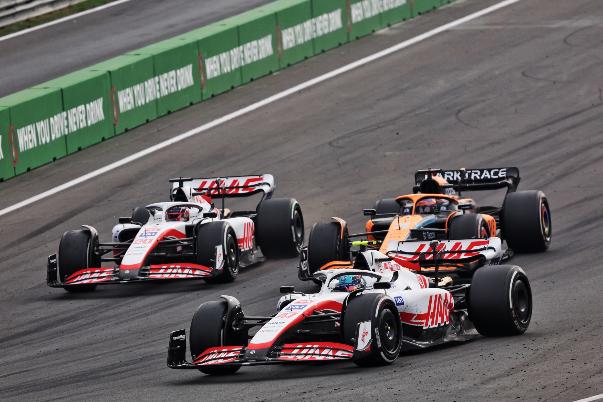 Mick Schumacher (GER) Haas VF-22 leads Kevin Magnussen (DEN) Haas VF-22 and Daniel Ricciardo (AUS) McLaren MCL36. Formula