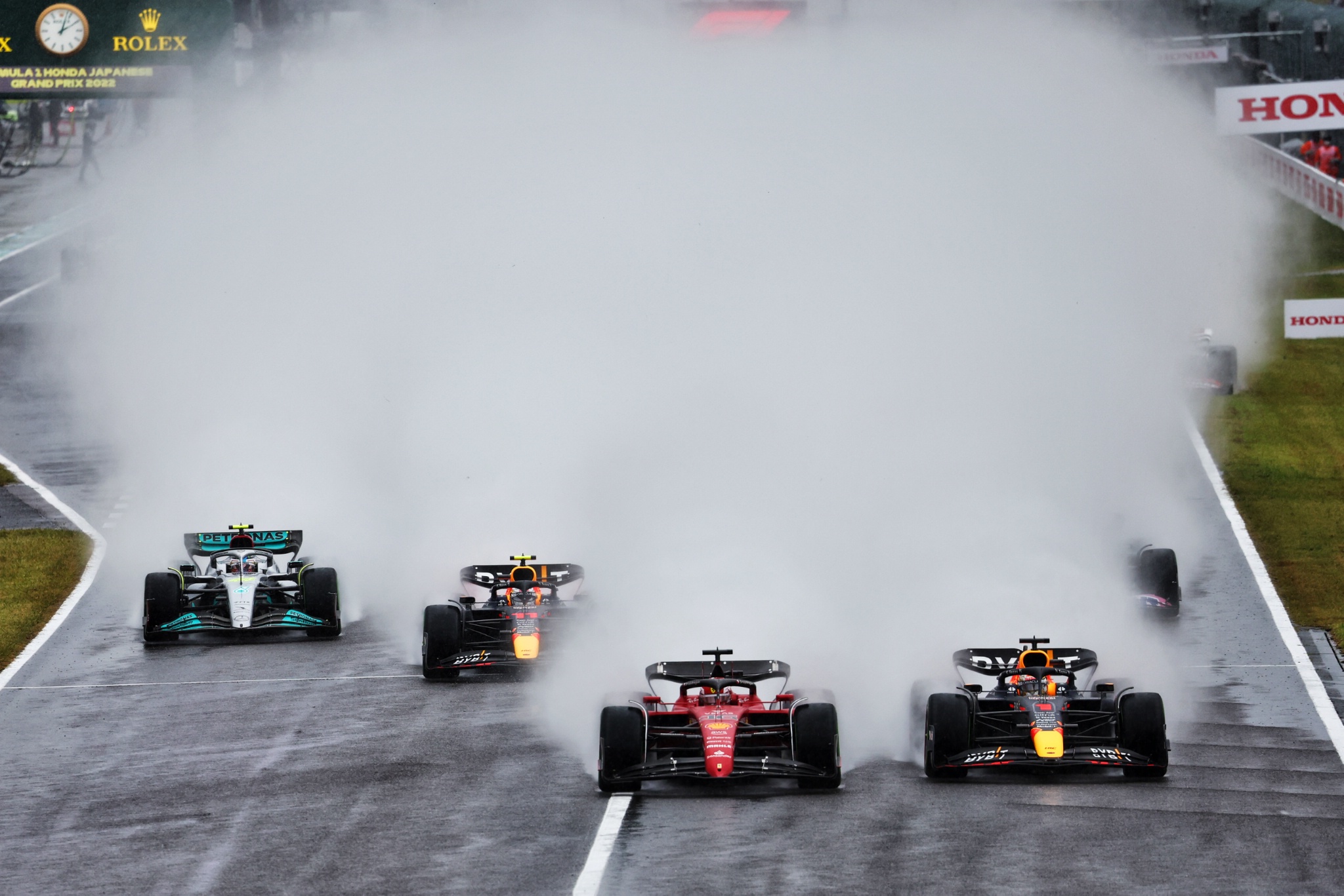 Max Verstappen (NLD) Red Bull Racing RB18 and Charles Leclerc (MON) Ferrari F1-75 battle for the lead at the start of the
