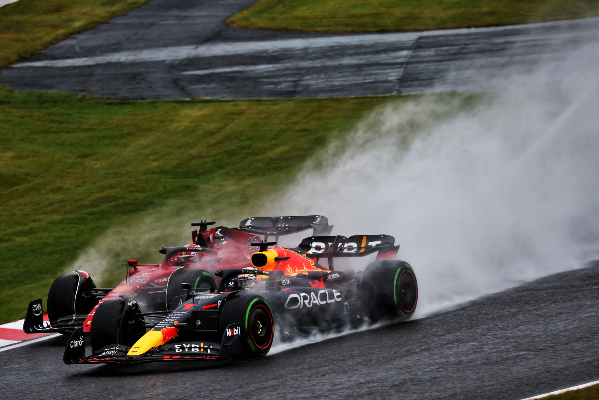 Max Verstappen (NLD) Red Bull Racing RB18 and Charles Leclerc (MON) Ferrari F1-75 battle for the lead at the start of the