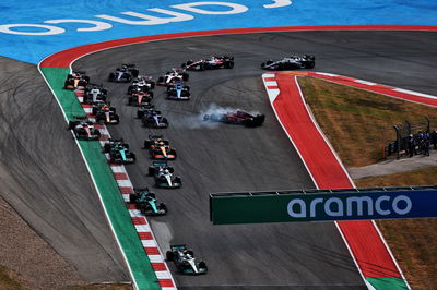 Max Verstappen (NLD) Red Bull Racing RB18 leads at the start of the race as Carlos Sainz Jr (ESP) Ferrari F1-75 is hit out