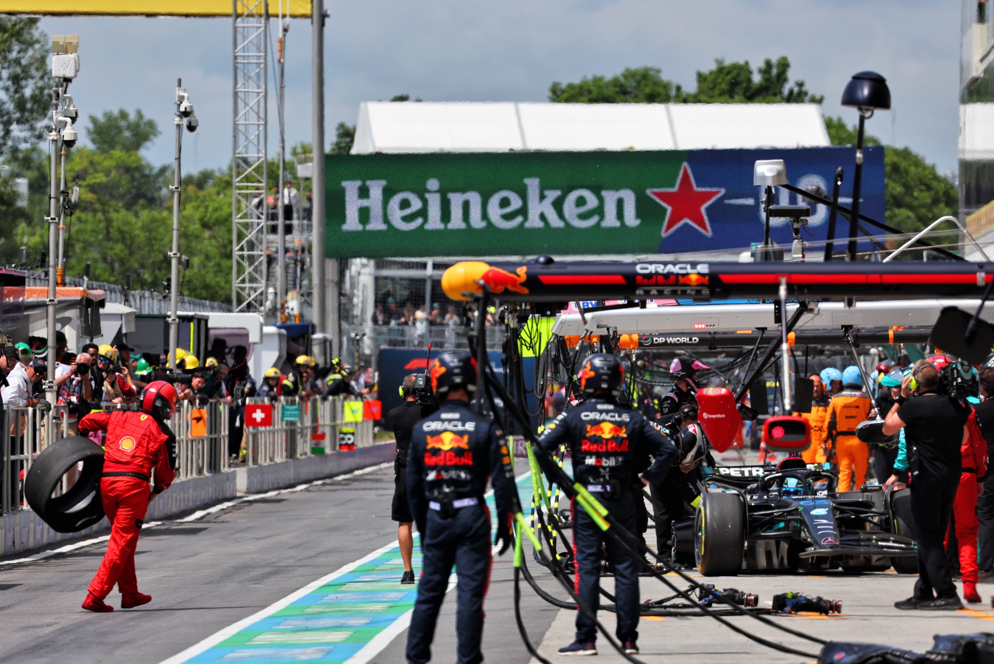 George Russell (GBR) Mercedes AMG F1 W14 makes a pit stop to fix damage as a Ferrari mechanic collects an errant wheel