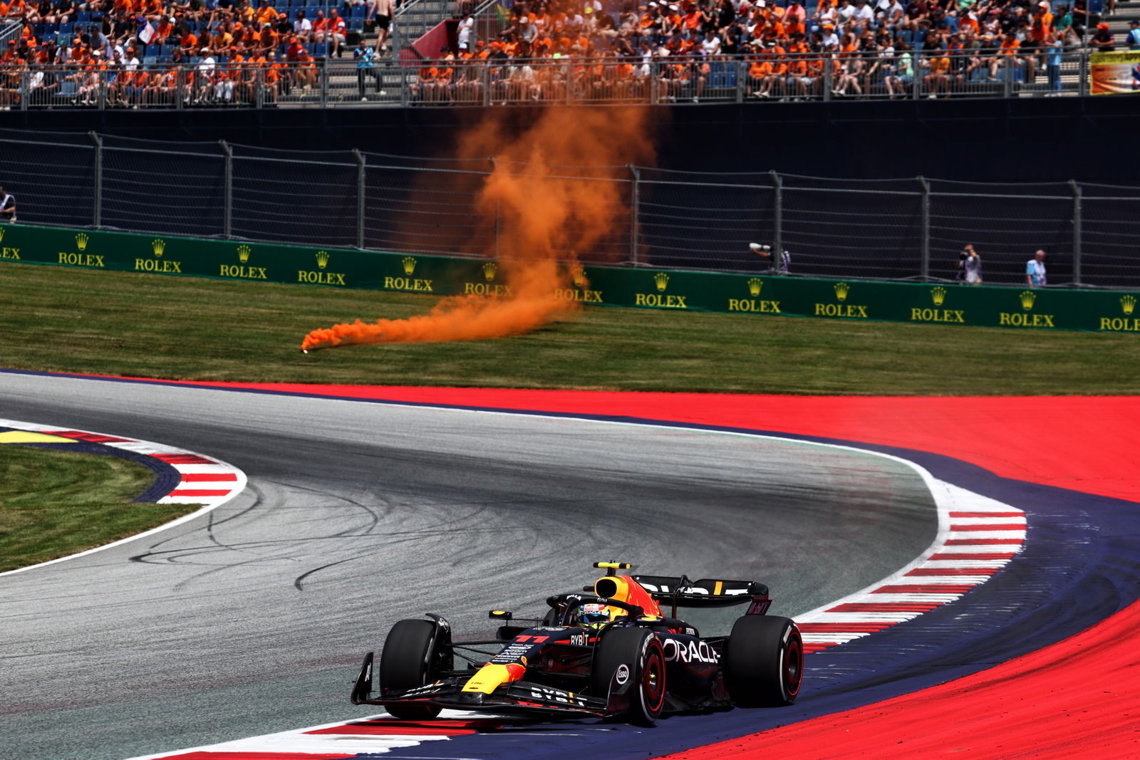 Sergio Perez (MEX) Red Bull Racing RB19 as an orange flare lands near the track. Formula 1 World Championship, Rd 10,