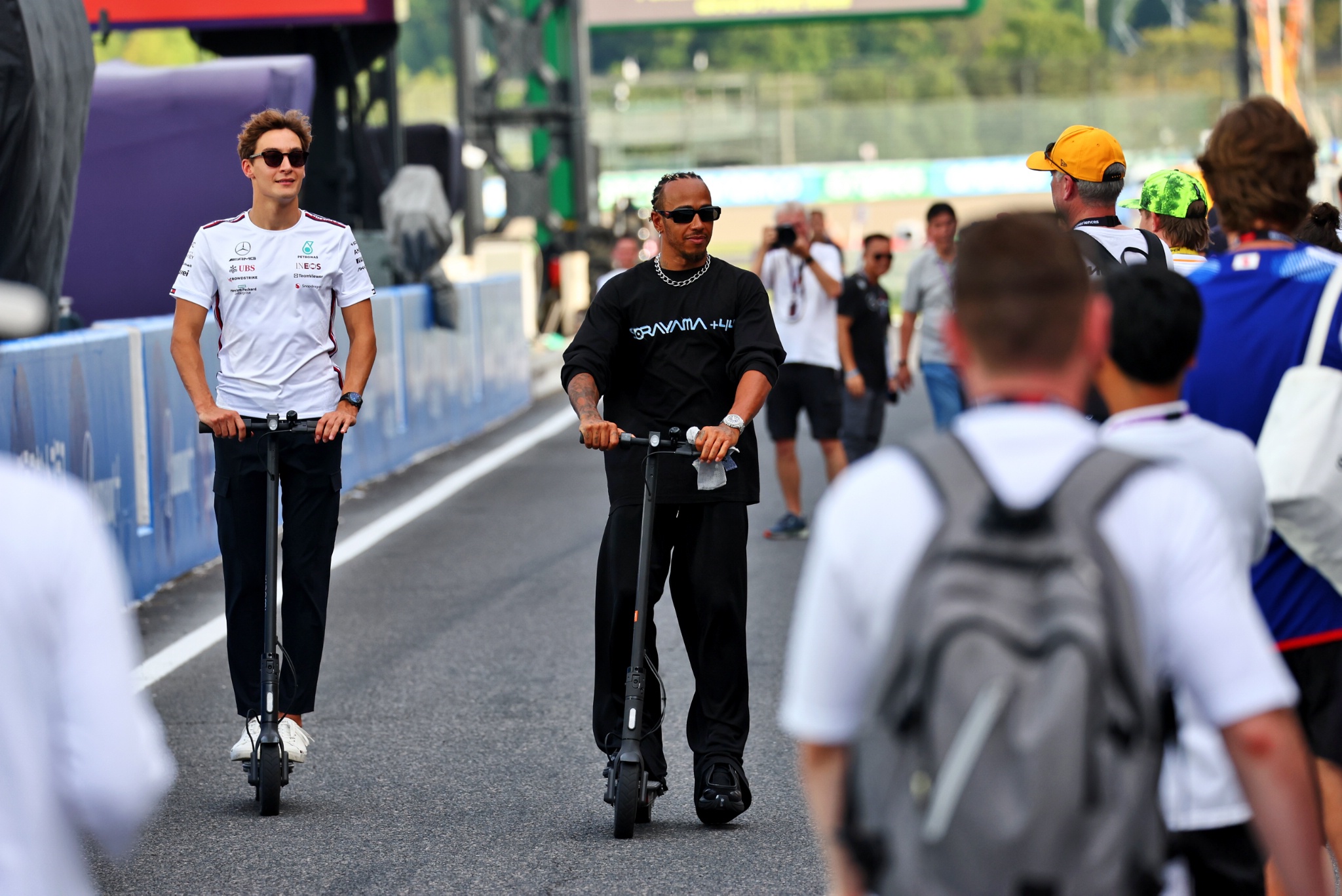 (L to R): George Russell (GBR) Mercedes AMG F1 with team mate Lewis Hamilton (GBR) Mercedes AMG F1 on scooters. Formula 1