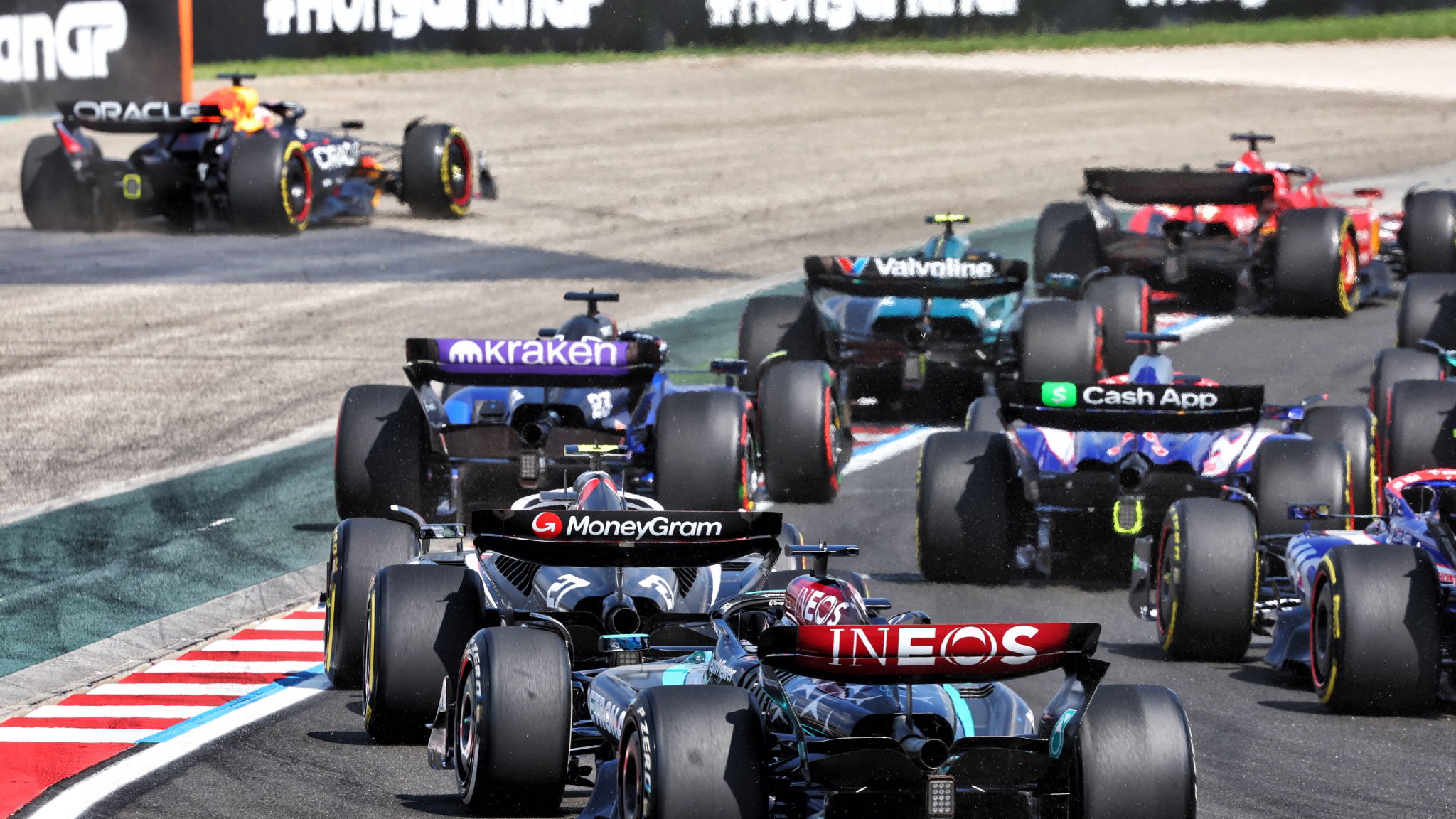 George Russell (GBR) Mercedes AMG F1 W15 at the start of the race as Max Verstappen (NLD) Red Bull Racing RB20 runs wide.