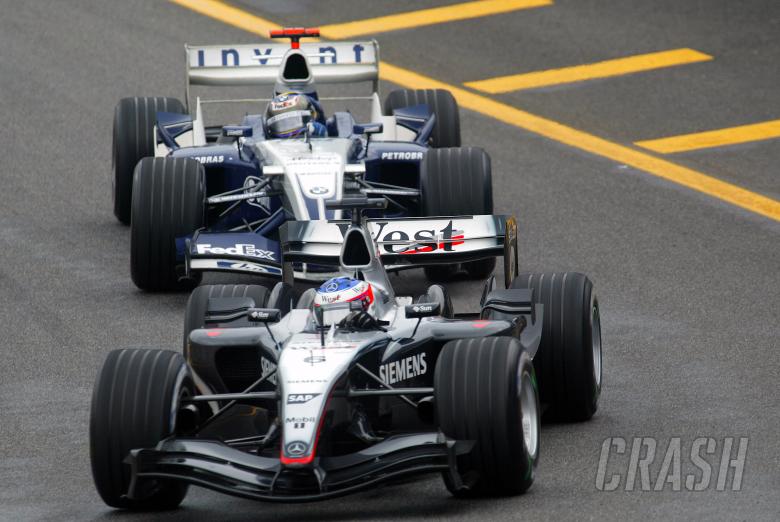 Kimi Raikkonen and Juan Pablo Montoya exit the pit-lane together during the Brazilian Grand Prix