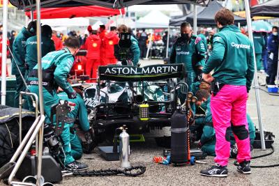 Sebastian Vettel (GER) Aston Martin F1 Team AMR21 on the grid with work being done on the rear brakes.
