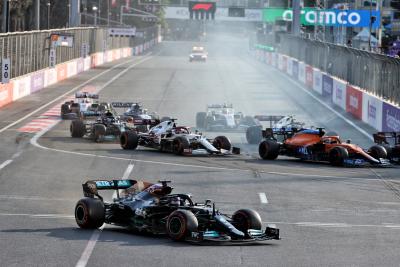 Lewis Hamilton (GBR) Mercedes AMG F1 W12 terkunci saat mengerem dan melebar saat memulai balapan saat mencoba melewati Sergio Perez (MEX) Red Bull Racing RB16B.