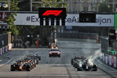(Kiri ke Kanan): Sergio Perez (MEX) Red Bull Racing RB16B dan Lewis Hamilton (GBR) Mercedes AMG F1 W12 saat memulai kembali balapan.