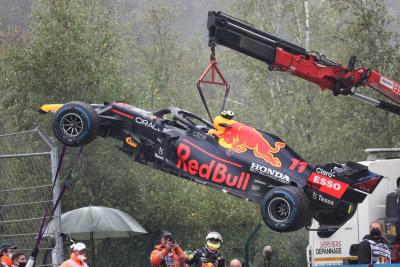 The Red Bull Racing RB16B of Sergio Perez (MEX) is craned away from the circuit after he crashed heading to the grid.