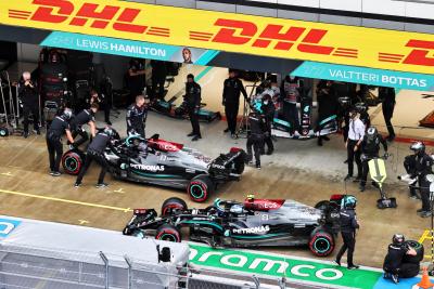 Lewis Hamilton (GBR) Mercedes AMG F1 W12 di pit dengan patah sayap depan di depan rekan setimnya Valtteri Bottas (FIN) Mercedes AMG F1 W12.