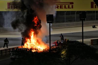 Marshals mengeluarkan kebakaran setelah Romain Grosjean (FRA) Haas F1 Team VF-20 jatuh di awal balapan dan meledak