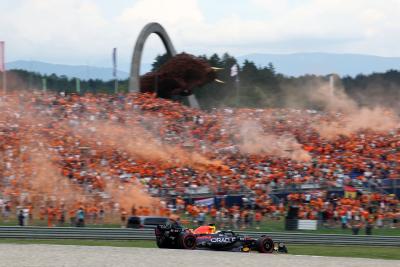 Max Verstappen (NLD) Red Bull Racing RB19 passes fans in the grandstand with flares being set off. Formula 1 World