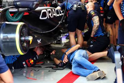 Adrian Newey (GBR) Red Bull Racing Chief Technical Officer looks under the Red Bull Racing RB20 of Sergio Perez (MEX) Red