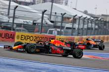 Lando Norris (GBR) McLaren MCL35M heads into the pits as Max Verstappen (NLD) Red Bull Racing RB16B passes him.